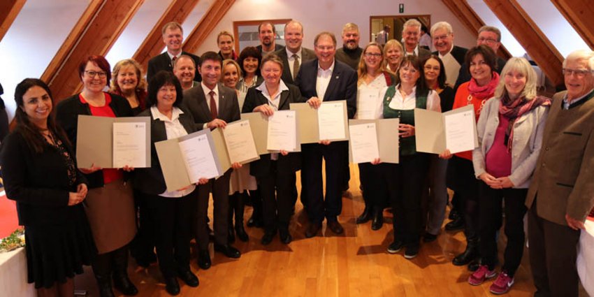 Ehrungsveranstaltung demenzfreundlicher Kommunen Die Vertreterinnen und Vertreter der neun Pilotgemeinden im Projekt „Demenzfreundliche Kommune“ erhielten von Landrat Christoph Göbel (2. Reihe, Mitte) im Rahmen einer Feierstunde im Festsaal des Landratsamts eine Ehrenurkunde für ihr umfangreiches Engagement zur Verbesserung der örtlichen Versorgungsstruktur für Demenzkranke und deren Angehörige.
