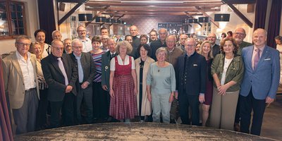 Foto: Die Geehrten stehen mit Landrat Christoph Göbel (ganz rechts) im Halbkreis vor der Bühne im Gasthof Gut Keferloh und lachen in die Kamera.