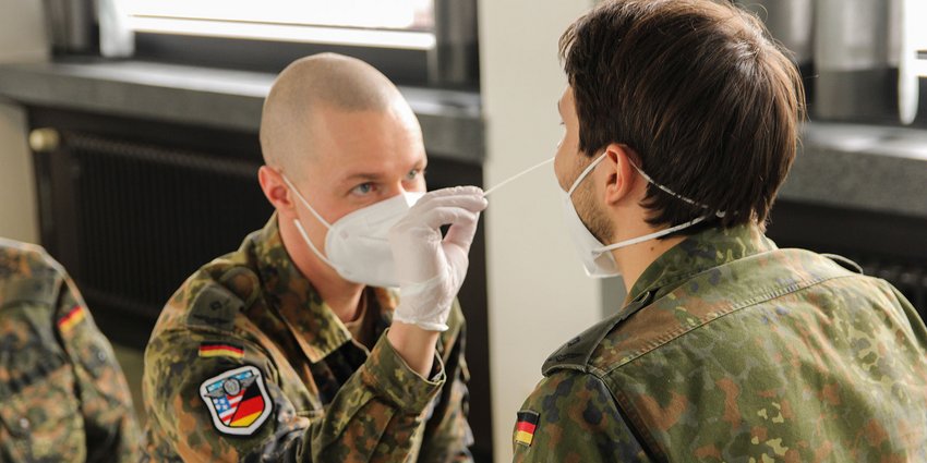 Foto: Ein Soldat nimmt bei einem Kameraden einen Nasenabstrich vor.