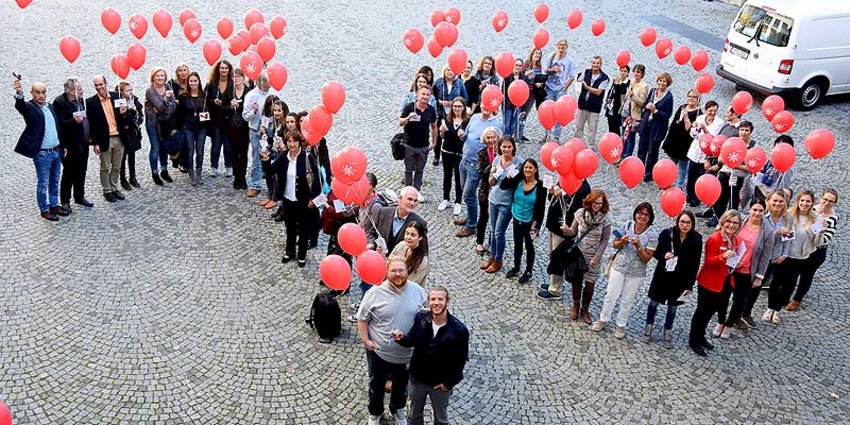 Foto: Mitarbeiter mit Luftballons.