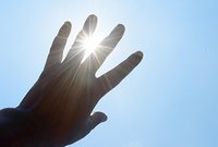 Bild: Person hält Hand hoch, um sich vor Sonne zu schützen
