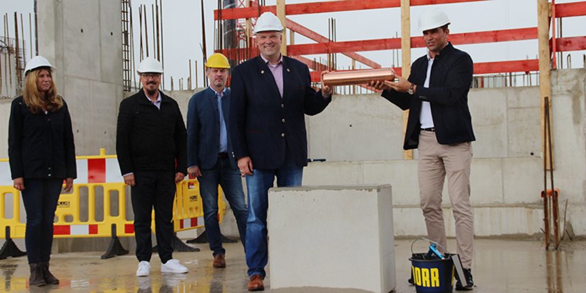 Grundsteinlegung Gymnasium Kirchheim Bild der Die Geschäftsleiterin des Zweckverbandes, Michèle Schlautmann, die Ersten Bürgermeister von Feldkirchen und Aschheim Andreas Janson und Thomas Glashauser, Münchens Landrat Christoph Göbel und Kirchheims Erster Bürgermeister Maximilian Böltl mit Grundstein und Zeitkapsel für den gymnasialen Neubau.