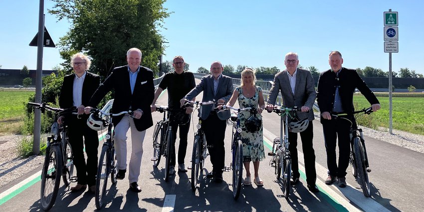Geben den neuen Radweg-Abschnitt nahe dem Skatepark in Garching für den Verkehr frei (v. l. n. r.): und Dr. Josef Rott, Abteilungsleiter im Bayerischen Staatsministerium für Wohnen, Bau und Verkehr, Landrat Christoph Göbel, Christoph Tegeler (Landeshauptstadt München), Martin Singer (Staatliches Bauamt Freising), Christine Volkmer, Prof. Christian Schiebel (beide Regierung von Oberbayern) und Garchings Zweiter Bürgermeister Christian Nolte.