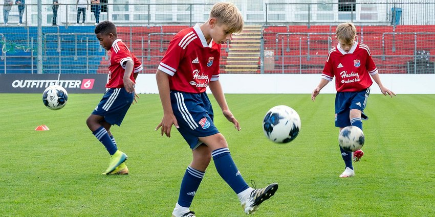 Volle Ballbeherrschung: Die jungen Talente aus dem Nachwuchsleistungszentrum der SpVgg Unterhaching zeigten ihr fußballerisches Können. Foto: Drei Jungen aus dem Nachwuchsleistungszentrum der SpVgg Unterhaching spielen Fußball.