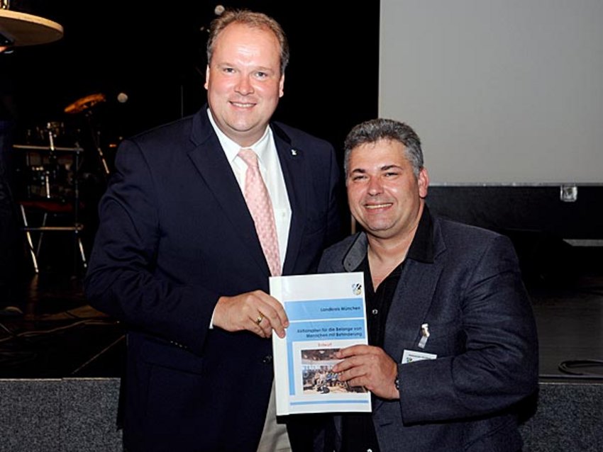 Foto: Die Teilnehmer der Abschlusskonferenz zum Aktionsplan UN-Behindertenrechtskonvention sitzen auf den bereitgestellten Plätzen und warten auf den Auftritt der integrativen Band Route Rockers vom Jugendkulturhaus Route 66 in Haar.