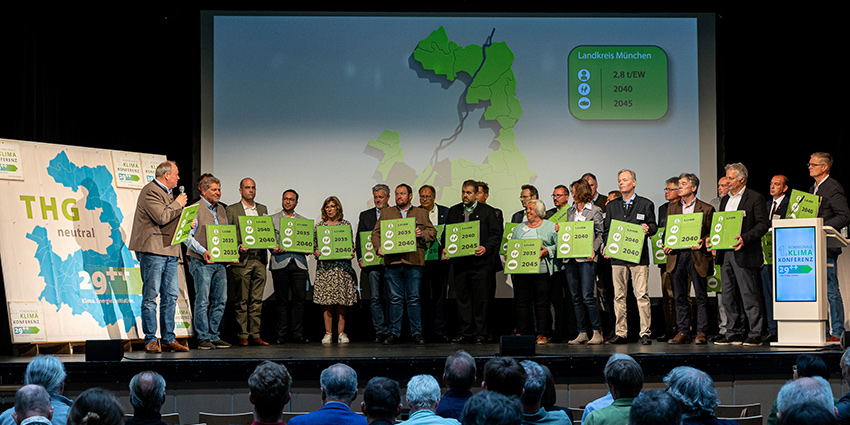 Jede der teilnehmenden Kommunen präsentierte ihre individuell festgelegten Ziele zur Erreichung der Klimaneutralität im Landkreis München. Foto: Die Bürgermeisterinnen und Bürgermeister präsentieren die kommunalen THG-Ziele