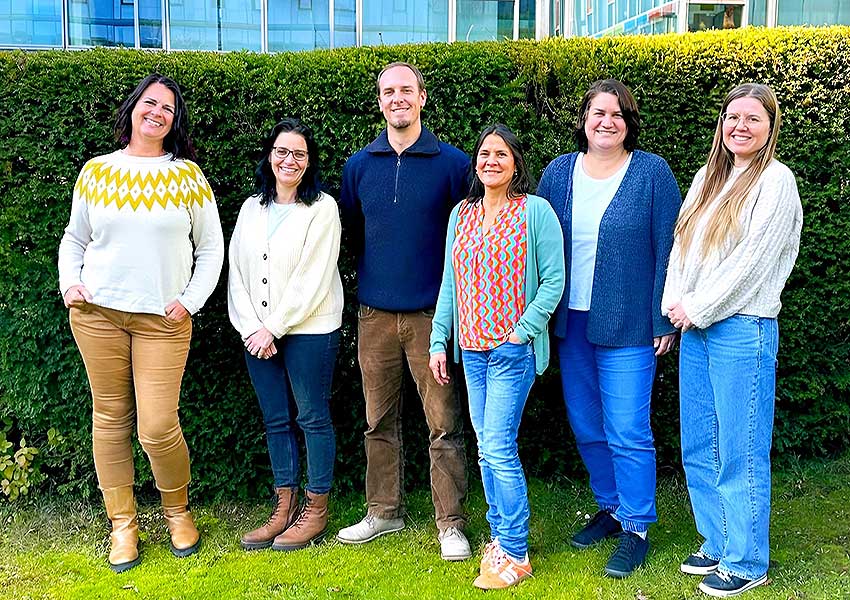 Foto: Fünf Frauen und ein Mann stehen vor einer Hecke. Sie sind das Team der Aufsuchenden Seniorenberatung im Landratsamt München.