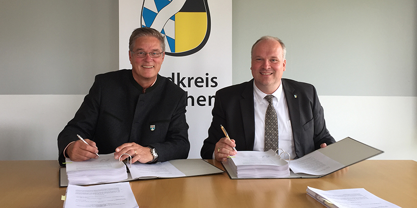 Foto: Garchings Erster Bürgermeister Dr. Dietmar Gruchmann und Landrat Christoph Göbel unterzeichnen im Landratsamt den Kaufvertrag.